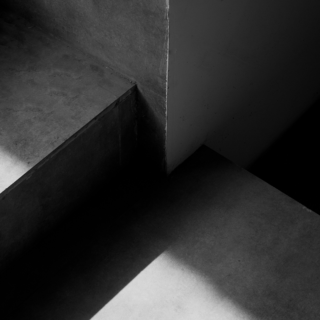 A serene architectural space capturing the play of light and shadow, embodying the brand philosophy of 'Ma' and invisible presence.
